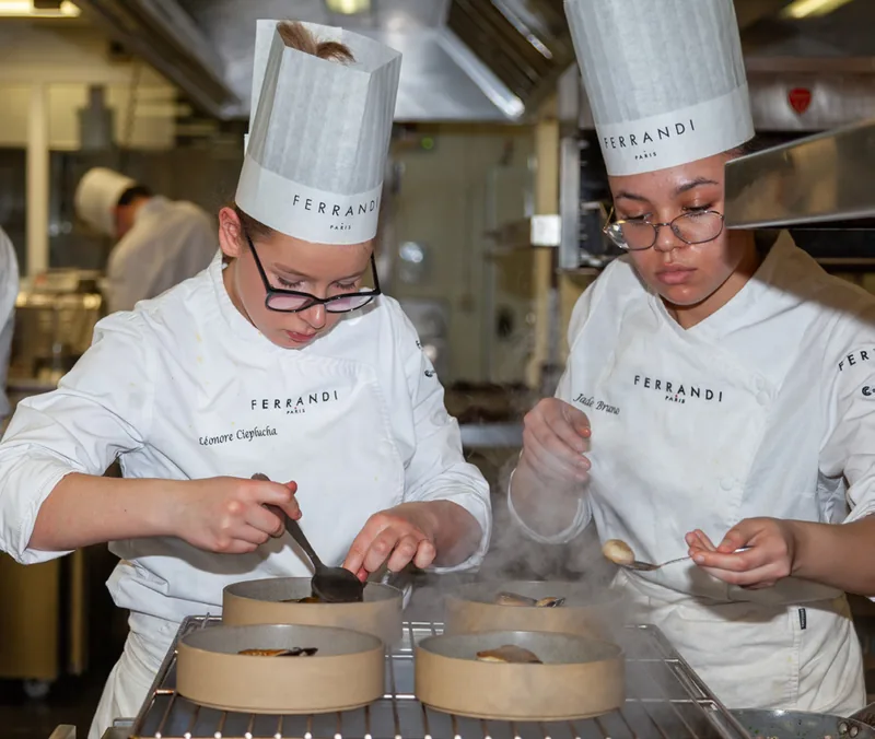 Élèves en concentration lors d'un exercice de dressage dans les cuisines de Ferrandi Paris.